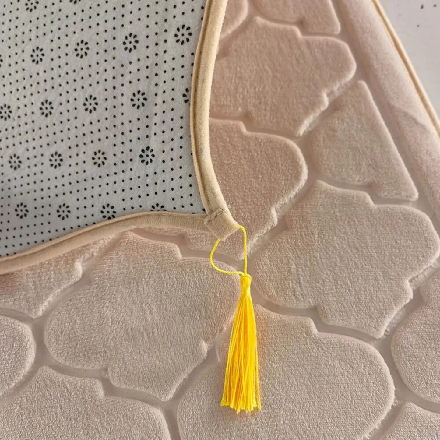 Close-up of Islamify foam padded prayer mat showing non-slip base, soft velvet texture, and yellow tassel