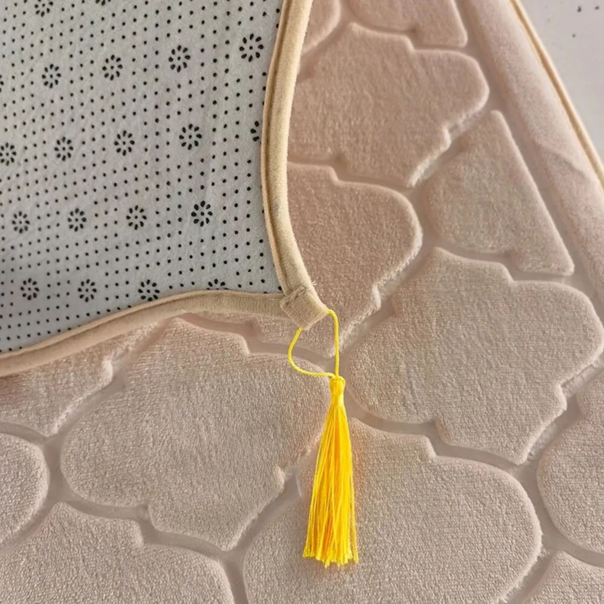 Close-up of Islamify foam padded prayer mat showing non-slip base, soft velvet texture, and yellow tassel