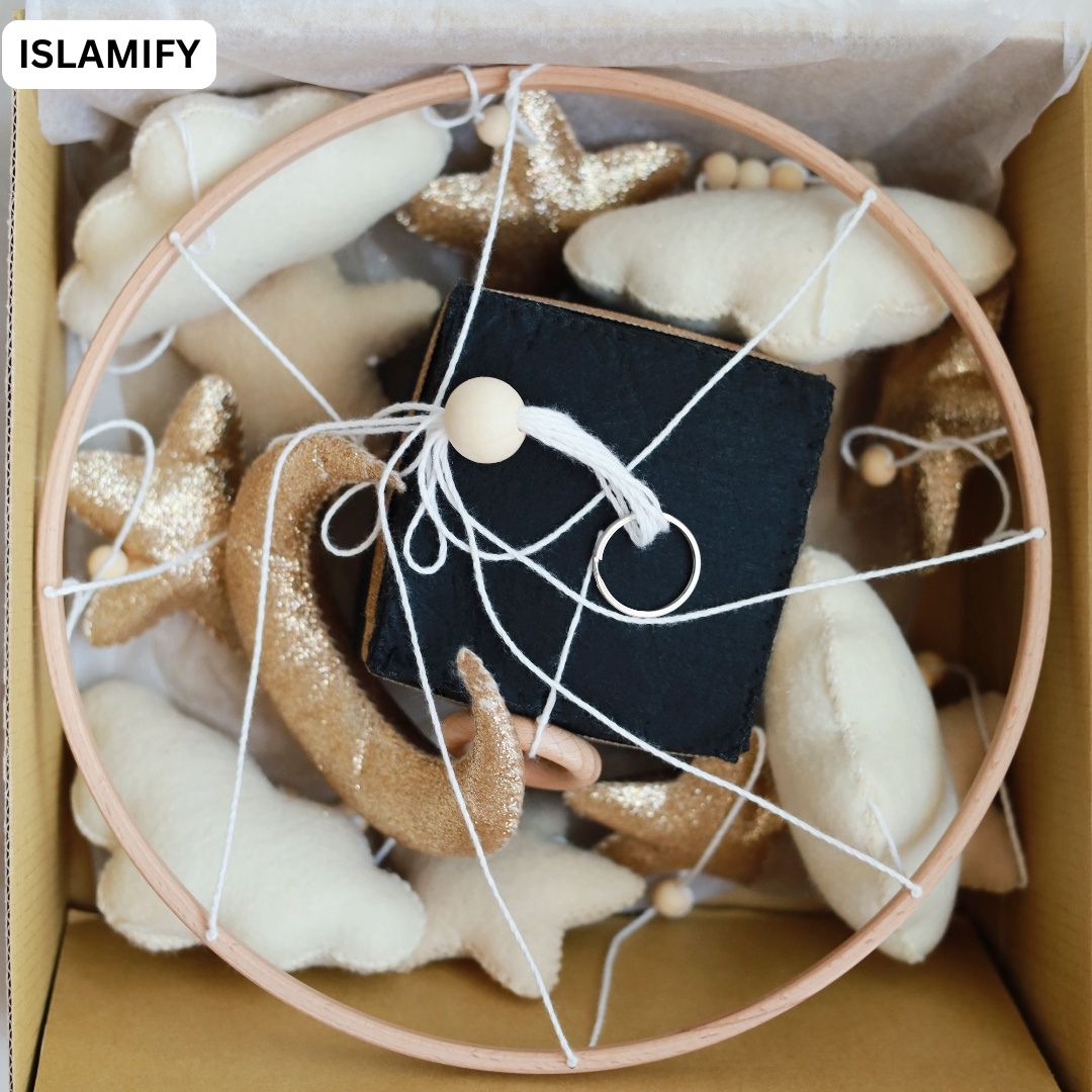 Quran Speaker Baby’s Edition gift box showing Kaaba centerpiece, plush clouds, stars, and crescent moon – Islamic baby mobile packaging by Islamify