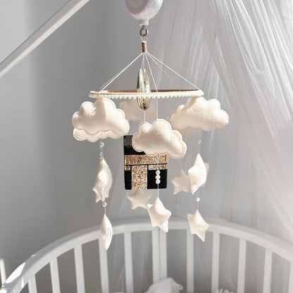 Islamic baby mobile Quran speaker featuring soft clouds, stars, and Kaaba design above a white crib – Quran lullaby for babies and nursery decor