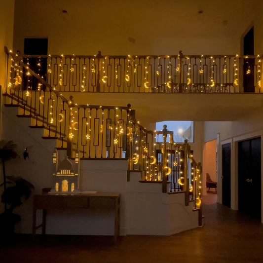 Warm Ramadan moon and star string lights decorating a staircase, creating a cozy festive ambiance for Eid and Ramadan nights by Islamify